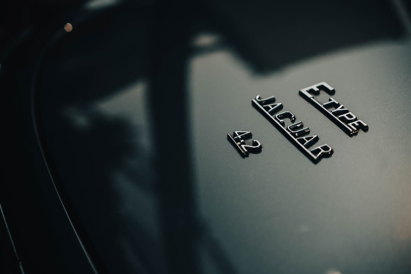 The E-Type 4.2 emblem on a dark Jaguar body